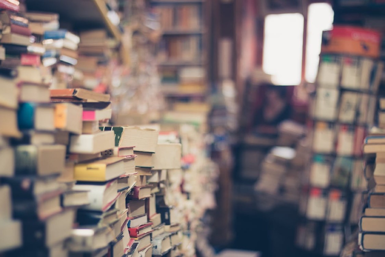 Libri antichi impilati con luce morbida, simbolo di apprendimento continuo sulle persone